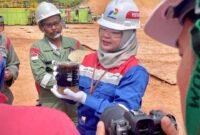 Caption foto: Afrilia Elisa, Sr Petroleum Engineer PHR, Kepala Proyek VENUS, tengah menunjukkan bejana berisi fluida lapisan minyak hasil dari sumur evaluasi menggunakan  VENUS.(yong/ist)