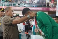 Pj BUpati Langkat Faisal Hasrimy menyerahkan mendali kepada sang juara di Cabor Sambo.(red)