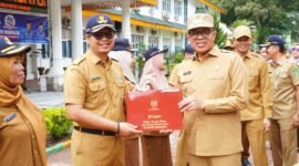 Pj Bupati Langkat Faisal Hasrimy saat memberikan penghargaan kepada salahsatu ASN di Langkat