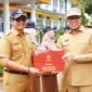 Pj Bupati Langkat Faisal Hasrimy saat memberikan penghargaan kepada salahsatu ASN di Langkat