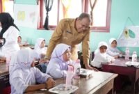Pj Bupati Langkat Faisal Hasrimy saat menyapa anak SD yang sedang menikmati makan siang gratis. Senin (16/12)