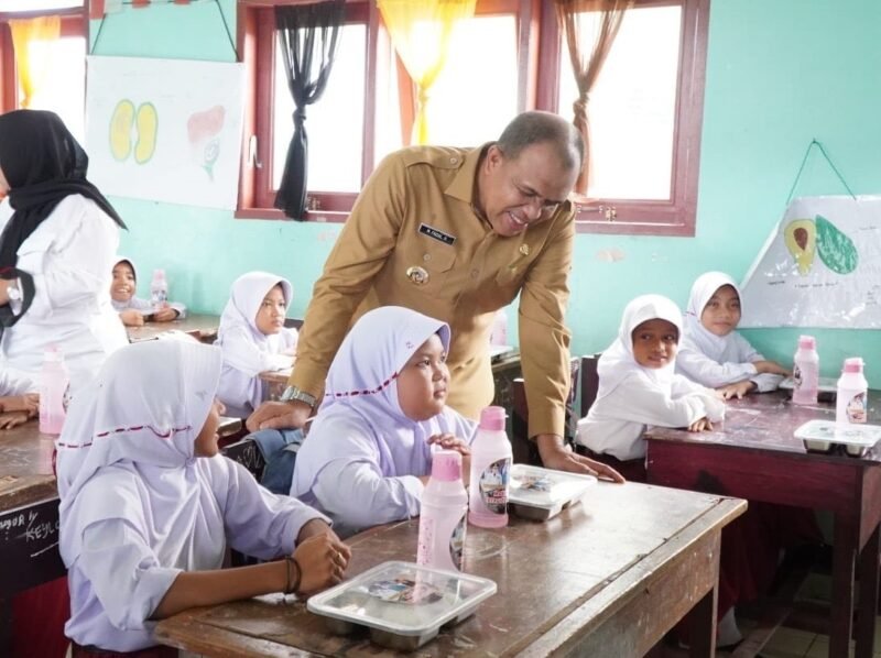 Pj Bupati Langkat Faisal Hasrimy saat menyapa anak SD yang sedang menikmati makan siang gratis. Senin (16/12)